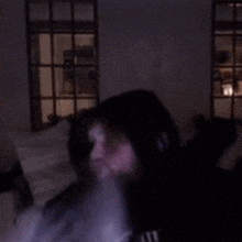 a man is smoking a cigarette in a dark room .