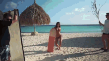 a woman in a bikini holds a surfboard on the beach