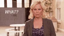 a woman in a suit says " what " in front of a picnic table