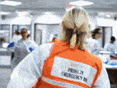 a woman is wearing an orange vest that says primary emergency on it