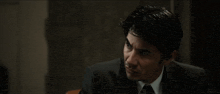 a man in a suit and tie is looking to the side