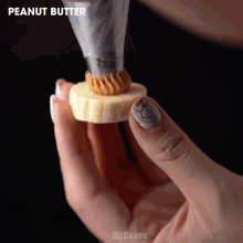 a person is holding a slice of banana with peanut butter on it