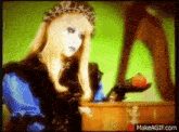 a woman with long blonde hair and a crown is holding an apple .