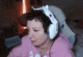 a woman wearing headphones is sitting in a chair in a room .