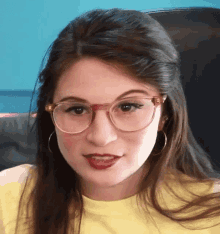 a close up of a woman wearing glasses and a yellow shirt