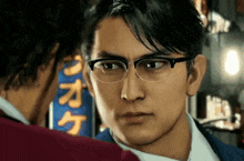 a man wearing glasses is looking at another man in front of a sign with chinese characters on it