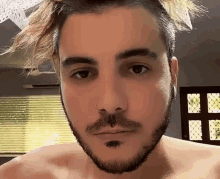 a man with a beard and a nose ring is looking at the camera