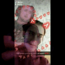 a man is taking a picture of himself with hearts on his face .