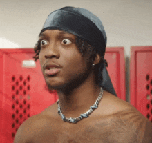 a shirtless man wearing a headband and a necklace