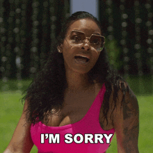 a woman in a pink tank top and sunglasses says i 'm sorry