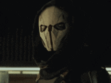 a close up of a person wearing a hooded mask in the dark .