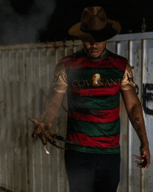 a man in a covenant shirt is holding a pair of claws