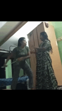 two women are standing next to each other in a room with a wardrobe .