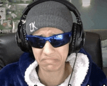 a man wearing headphones and sunglasses is making a face