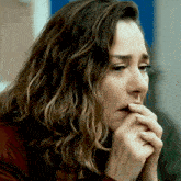 a close up of a woman 's face with her hand on her mouth