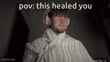 a man is wrapped in a blanket and headphones with the words `` this healed you '' above him .