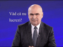 a man in a suit and tie with the words vad ca nu lucrezi behind him