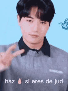 a young man is giving a peace sign with the words haz si eres de jud written below him
