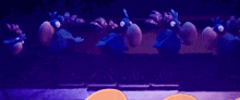 a group of blue birds are standing next to each other on a wall .