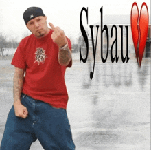 a man in a red shirt giving the middle finger in front of a sybau logo