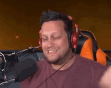 a man wearing headphones and a microphone is sitting in front of a microphone .