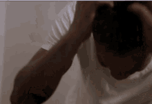 a man in a white shirt is holding his head with his hands