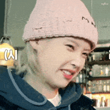 a woman wearing a pink hat and a blue jacket is smiling