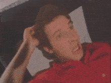 a man in a red shirt has the number 322907 on the bottom
