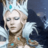 a close up of a woman wearing a crown and a feathered costume with her eyes closed .