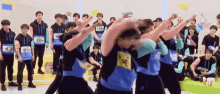 a group of young men are dancing in a room and one of them has a name tag that says ' x15 ' on it