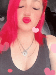 a woman with red hair is wearing a black tank top and a necklace with a lock on it