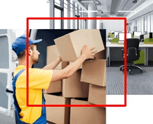 a man carrying a cardboard box in an office