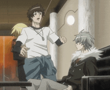 a man in a white t-shirt is talking to another man