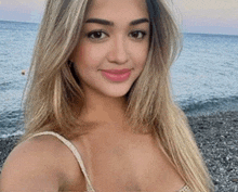 a woman is taking a selfie on the beach .