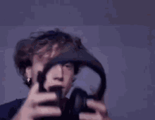 a young man is wearing headphones on his head and looking at the camera .