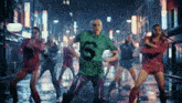 a woman in a green shirt with the letter s on it is dancing