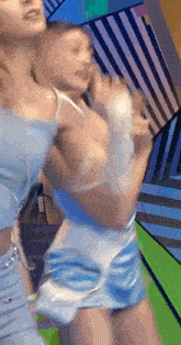 a blurry picture of two women dancing in front of a colorful background