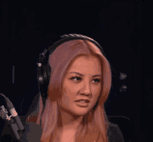 a woman with pink hair is wearing headphones and a microphone with the number 88 on it