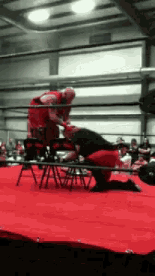 two men are wrestling in a ring and one is kneeling on the floor