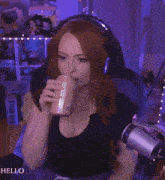 a woman is sitting in a chair holding a can of soda .