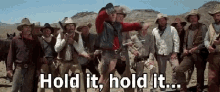 a group of cowboys are standing in a line with the words hold it hold it written on the bottom