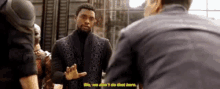 a man in a suit is talking to another man while standing next to a group of people .