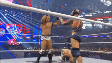 two wrestlers are standing in a ring and one of them is wearing a shirt that says ' king ' on it