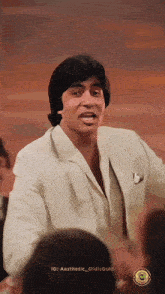 a man in a white suit is standing in front of a group of people with the caption aesthetic oldisgold