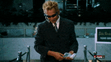 a man in a suit and tie is standing in front of a sign that says site brief