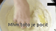 a person kneading a dough in a bowl with the words mhm toto je pocit