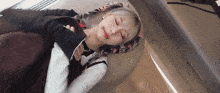 a woman with pigtails is sleeping on a couch