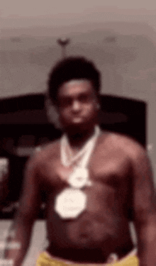 a shirtless man is wearing a medal around his neck .