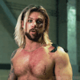 a man with long blonde hair and a beard has a tattoo on his shoulder