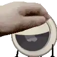 a close up of a person 's hand holding a plate with a smiley face on it .